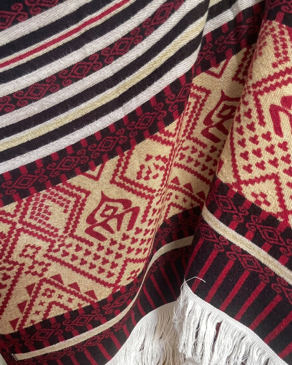 poncho-peruvien-franges-motif-ethnique-rouge-closeup